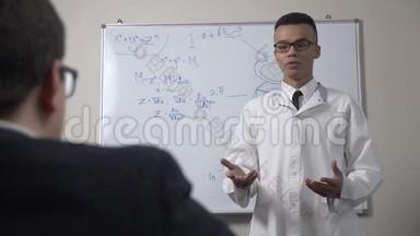 一位年轻成功的非洲科学家身穿白色外套和眼镜，站在黑板前，拿着公式和演示文稿